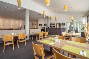 a dining room with wooden tables and chairs at Center Hotel Kaiserhof in Naumburg