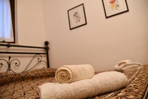 a bed with two rolled towels on top of it at Villa Rico Masseria nel Parco in Caramanico Terme