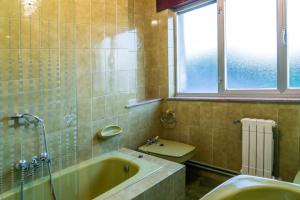 ビベイロにあるPiso con excelentes vistasのバスルーム(バスタブ、トイレ付)、窓が備わります。