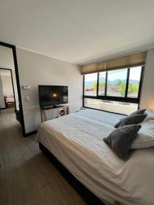 a bedroom with a large bed and a large window at Fabuloso depto 2d/2b en Metro Los Dominicos in Santiago