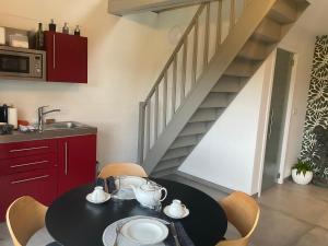 uma cozinha com uma mesa e cadeiras pretas e uma escadaria em Lovely 1-bedroom appartement Le Joyau with indoor pool and sauna em Lasne