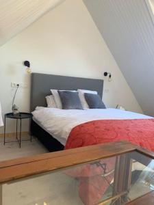 a bedroom with a bed with a red comforter at Lovely 1-bedroom appartement Le Joyau with indoor pool and sauna in Lasne