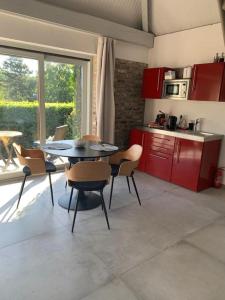 een keuken met een tafel en stoelen in een kamer bij Lovely 1-bedroom appartement Le Joyau with indoor pool and sauna in Lasne