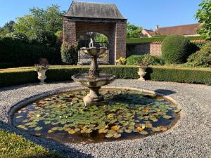 a water fountain with lilies in a garden at Lovely 1-bedroom appartement Le Joyau with indoor pool and sauna in Lasne
