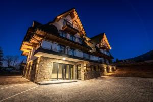 a building with a lit up facade at night at Aparthotel Zakopane in Zakopane