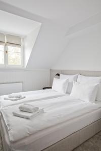 a white bed with white pillows and towels on it at Port Sołacz in Poznań