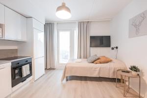 a white bedroom with a bed and a tv at Forenom Serviced Apartments Jyväskylä Vaasankatu in Jyväskylä