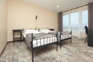 a bedroom with two beds and a desk and a window at Branša in Telšiai +91 photos