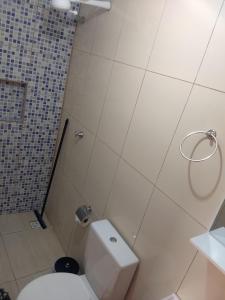 y baño con aseo blanco y ducha. en Kitnets casa Amarela Imbassai, en Imbassai