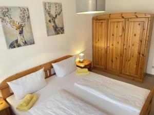 a bedroom with a bed and a wooden cabinet at Ferienwohnung Alpenglück in Steibis