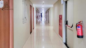 a corridor of a hospital with a fire extinguisher at Kozii Room at Evenciio Apartment in Pondokcina