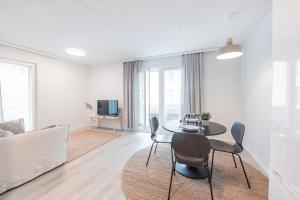 a white living room with a table and chairs at Forenom Serviced Apartments Jyväskylä Vaasankatu in Jyväskylä