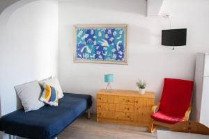 sala de estar con sofá azul y silla roja en Apartamentos Central, en Quarteira