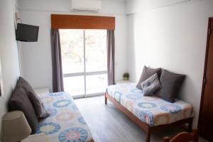 um quarto com uma cama, um sofá e uma janela em Apartamentos Central em Quarteira