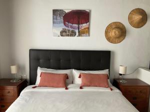 una camera da letto con un grande letto con due cuscini di Casa de las Especias Hotel Boutique a Sanlúcar de Barrameda
