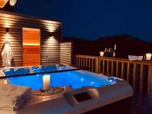 a jacuzzi tub sitting on a deck at night at Die Tauplitz Lodges - Penthouse Grimming D7-1 by AA Holiday Homes in Tauplitz