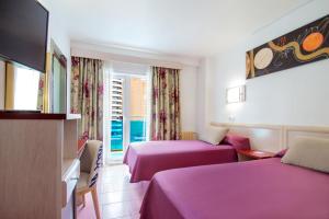 a hotel room with two beds and a flat screen tv at Hotel Servigroup Venus in Benidorm