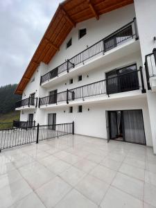 Un gran edificio blanco con balcones y un patio. en ANDRADA WEDDING HALL, en Repedea