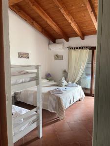 a bedroom with two bunk beds and a wooden ceiling at Donnigheddu in Rudalza