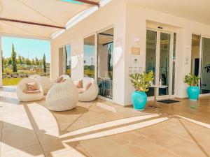 uma sala de estar com cadeiras, mesas e janelas em Relais Masseria Le Cesine - CDSHotels em Vernole