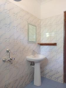 a bathroom with a white sink and a mirror at Atlas Hotel Paje in Paje