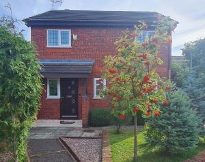 ein rotes Backsteinhaus mit einem Baum davor in der Unterkunft Spacious, 5 bed house for 9 in Chester in Chester