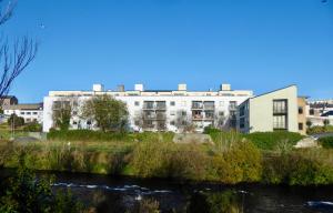 a building with a river in front of it at Assaroe Falls in Ballyshannon