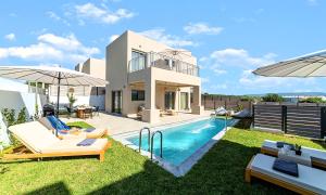 a villa with a swimming pool and a house at KS Luxury Villas Heated Pools in Georgioupolis