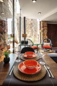 una mesa con dos platos y copas de vino. en DUO SOMNIA, suites con jacuzzi y chimenea, only adults, 