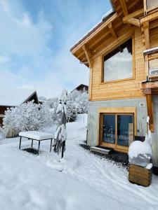 a statue in the snow in front of a house at Gîte Au Balcon de Passy/Plaine Joux, classé 2 ** in Passy