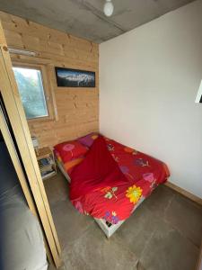 a small bedroom with a red bed in the corner at Gîte Au Balcon de Passy/Plaine Joux, classé 2 ** in Passy