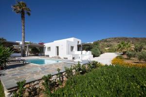 a villa with a swimming pool and a palm tree at Villa Aphrodite · Elegant villa, sea views, designer renovation in Ambelas