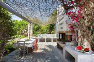 an outdoor patio with a table and a fireplace at Villa Aphrodite · Elegant villa, sea views, designer renovation in Ambelas