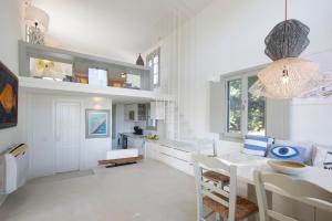 a white kitchen with a table and a dining room at Villa Aphrodite · Elegant villa, sea views, designer renovation in Ambelas