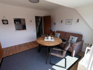 ein Wohnzimmer mit einem Tisch und einem Sofa in der Unterkunft Sylter Finke Appartement in Wenningstedt-Braderup