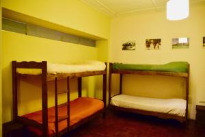 a room with three bunk beds in a room at Areco hospedaje in San Antonio de Areco