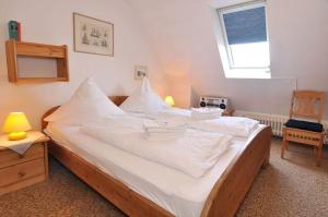 ヴェニングシュテットにあるSylter-Finke-Appartementのベッドルーム(白いシーツを使用した大型ベッド1台付)