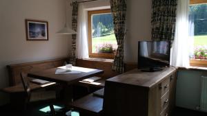 ein Esszimmer mit einem Tisch und einem TV sowie einem Tisch und Stühlen in der Unterkunft Alt Poschach in Obergurgl