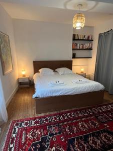 a bedroom with a large bed and a red rug at Jupiter YourHostHelper in Caen