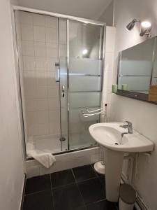 La salle de bains est pourvue d'une douche et d'un lavabo. dans l'établissement Jupiter YourHostHelper, à Caen