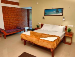 a bedroom with a large bed and a chair at Dr Nisha's Vedic Remedies in Trivandrum