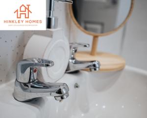 a bathroom sink with a faucet and a mirror at Comfy 4bed Home - Free Parking, Wifi - Long Stays Welcome By Hinkley Homes Short Lets & Serviced Accommodation in Litherland