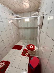 a bathroom with a toilet with a red seat at Casa Estrela Guia in Urubici