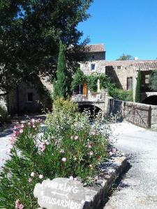 a garden with flowers in front of a house at Le Mas de la Musardiere chambres d hotes in Les Assions