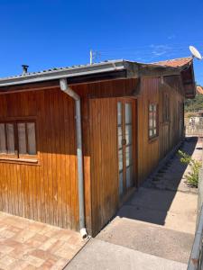 un edificio de madera con una puerta grande en Casa Estrela Guia en Urubici