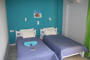 two beds in a room with blue walls at Nereides Hotel in Kolymvari