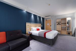 um quarto de hotel com uma cama e um sofá em Holiday Inn Express Burnley M65 Jct 10, an IHG Hotel em Burnley