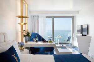 I Resort Beach Hotel & Spa في ستاليدا: غرفة نوم مع سرير وإطلالة على المحيط