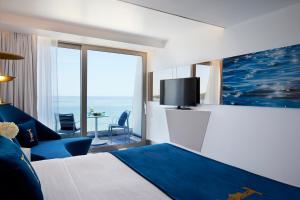 ein Hotelzimmer mit Bett und Blick aufs Meer in der Unterkunft I Resort Beach Hotel & Spa in Stalida