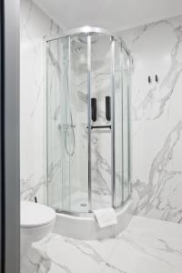 biała łazienka z prysznicem i umywalką w obiekcie Port Sołacz w Poznaniu